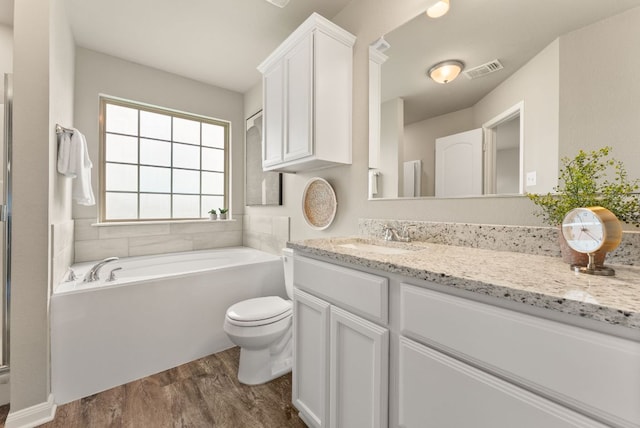 1910 Lummus Dr, Temple, TX 76504 - bathroom with vanity, wood finished floors, a bath, and toilet