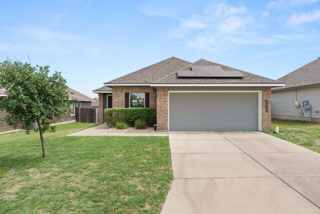 1910 Lummus Dr, Temple, TX 76504 - view of front of home with brick siding, roof mounted solar panels, an attached garage, and a shingled roof