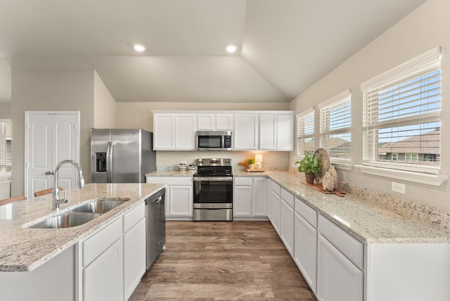 1910 Lummus Dr, Temple, TX 76504 - kitchen featuring appliances with stainless steel finishes, a sink, lofted ceiling, white cabinetry, and wood finished floors