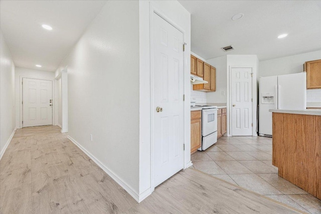 110 Rinehardt St, Hutto, TX 78634 - kitchen with white appliances, light countertops, under cabinet range hood, baseboards, and recessed lighting