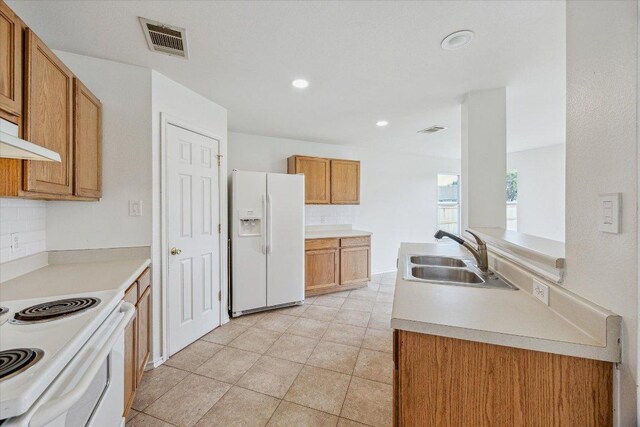 110 Rinehardt St, Hutto, TX 78634 - kitchen featuring white appliances, a sink, brown cabinets, light countertops, and decorative backsplash