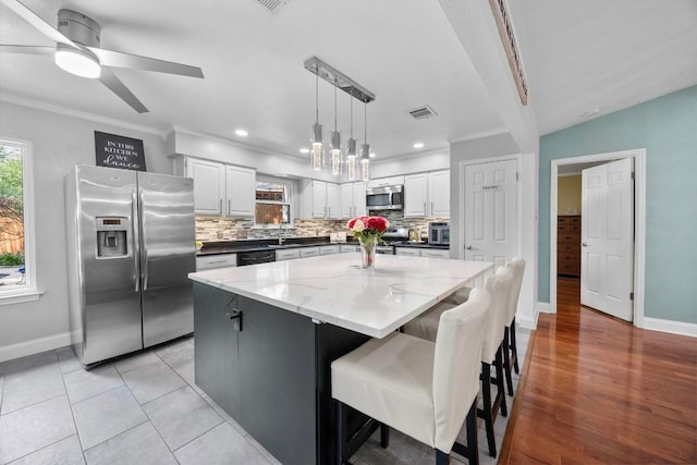 13210 Dime Box Trl, Austin, TX 78729 - kitchen with appliances with stainless steel finishes, baseboards, tasteful backsplash, ornamental molding, and white cabinets