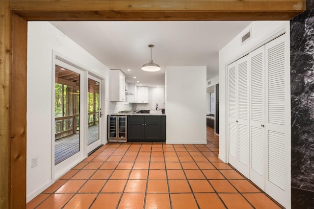 5902 Tumbling Cir, Austin, TX 78731 - kitchen featuring wine cooler, light tile patterned flooring, decorative light fixtures, light countertops, and white cabinets