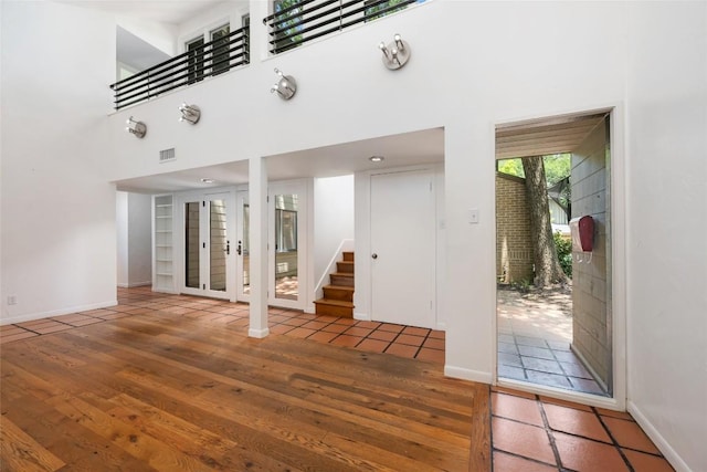 5902 Tumbling Cir, Austin, TX 78731 - entrance foyer with stairway, wood finished floors, a towering ceiling, and baseboards