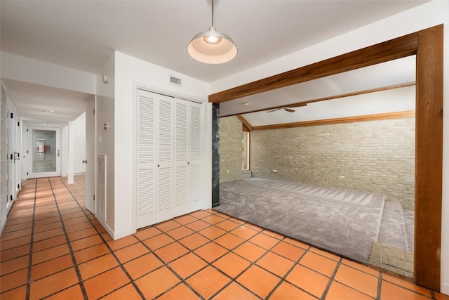 5902 Tumbling Cir, Austin, TX 78731 - unfurnished bedroom featuring brick wall, tile patterned floors, and a closet