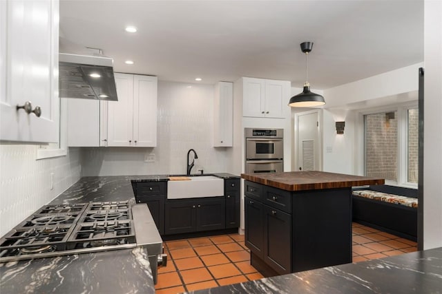 5902 Tumbling Cir, Austin, TX 78731 - kitchen with a sink, butcher block counters, white cabinets, range hood, and tasteful backsplash