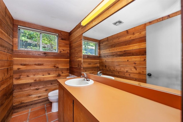 5902 Tumbling Cir, Austin, TX 78731 - bathroom with toilet, healthy amount of natural light, vanity, wood walls, and tile patterned flooring