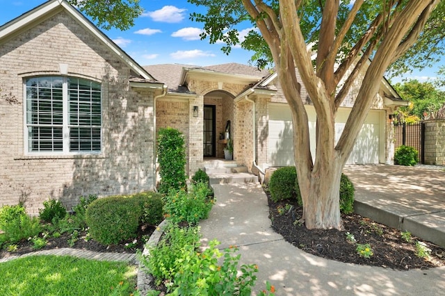 10239 Scull Creek Dr, Austin, TX 78730 - view of front of home with brick siding, an attached garage, concrete driveway, and roof with shingles