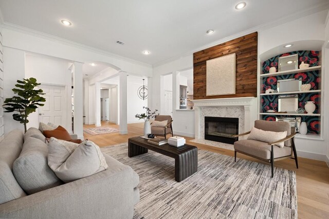 10239 Scull Creek Dr, Austin, TX 78730 - living room with ornate columns, crown molding, light wood-style flooring, recessed lighting, and a premium fireplace