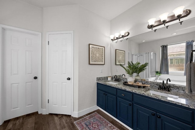 122 Retama Dr, Georgetown, TX 78626 - bathroom with double vanity, wood finished floors, a tub to relax in, a stall shower, and baseboards