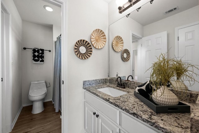 122 Retama Dr, Georgetown, TX 78626 - bathroom with vanity, wood finished floors, toilet, and baseboards