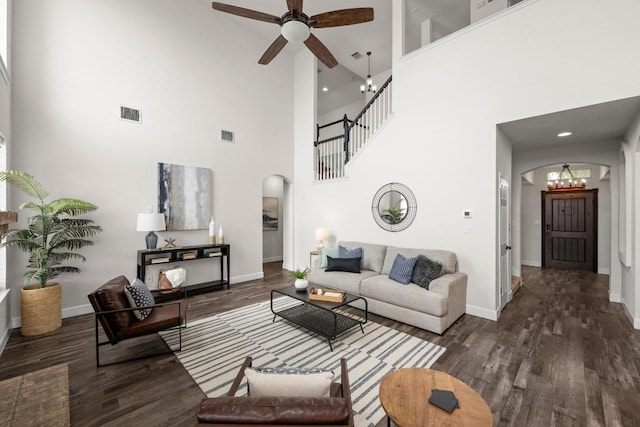 122 Retama Dr, Georgetown, TX 78626 - living room with arched walkways, a towering ceiling, wood finished floors, a chandelier, and a ceiling fan
