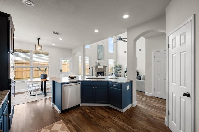 122 Retama Dr, Georgetown, TX 78626 - kitchen featuring stainless steel dishwasher, open floor plan, a sink, a fireplace, and dark wood-style flooring