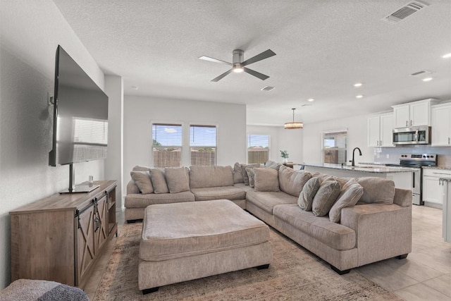 609 Ibis Falls Loop, Jarrell, TX 76537 - living area with ceiling fan, a textured ceiling, recessed lighting, and light tile patterned floors
