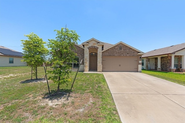 609 Ibis Falls Loop, Jarrell, TX 76537 - view of front facade with an attached garage, driveway, a front yard, and stone siding