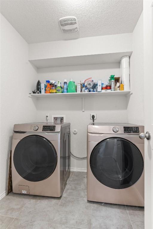 609 Ibis Falls Loop, Jarrell, TX 76537 - laundry area with independent washer and dryer, a textured ceiling, and light tile patterned flooring