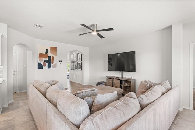 609 Ibis Falls Loop, Jarrell, TX 76537 - living room with arched walkways, a ceiling fan, and baseboards