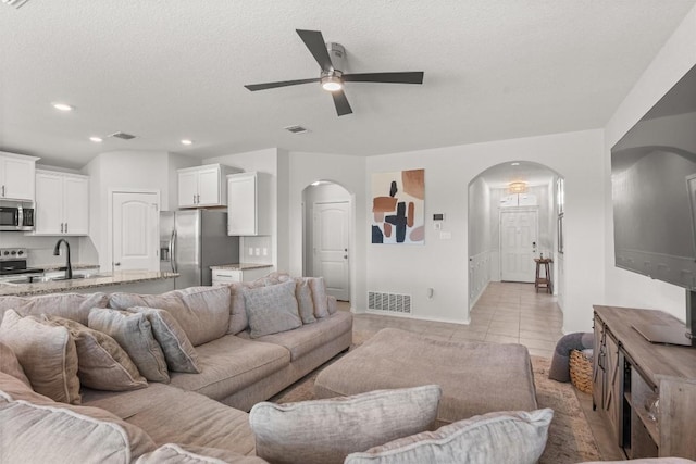 609 Ibis Falls Loop, Jarrell, TX 76537 - living room with arched walkways, ceiling fan, light tile patterned flooring, recessed lighting, and baseboards