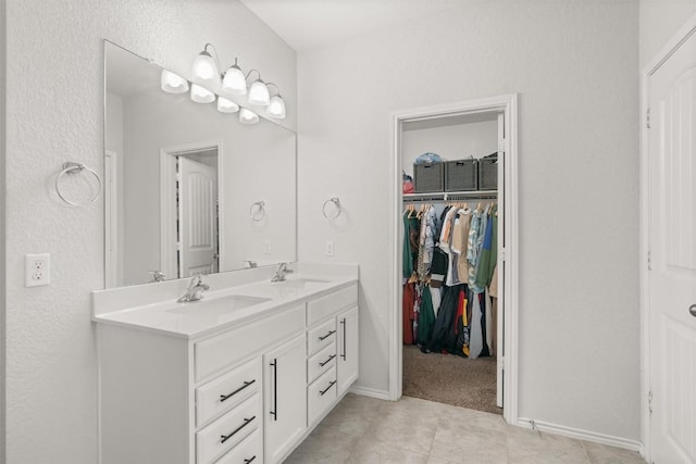 609 Ibis Falls Loop, Jarrell, TX 76537 - full bathroom featuring double vanity, baseboards, tile patterned floors, and a spacious closet