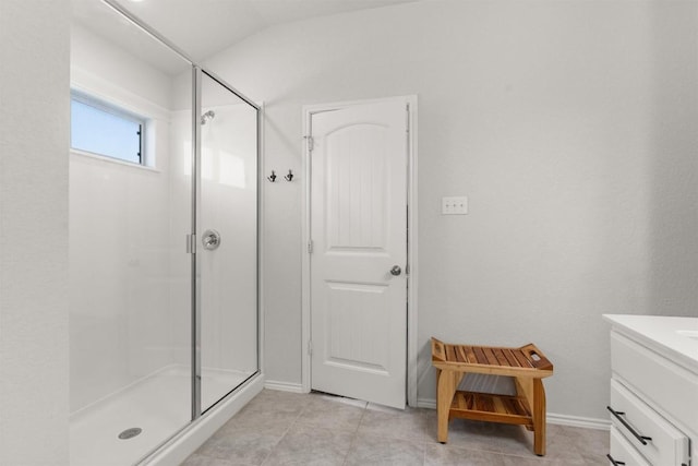 609 Ibis Falls Loop, Jarrell, TX 76537 - full bath with a stall shower, vanity, tile patterned floors, lofted ceiling, and baseboards