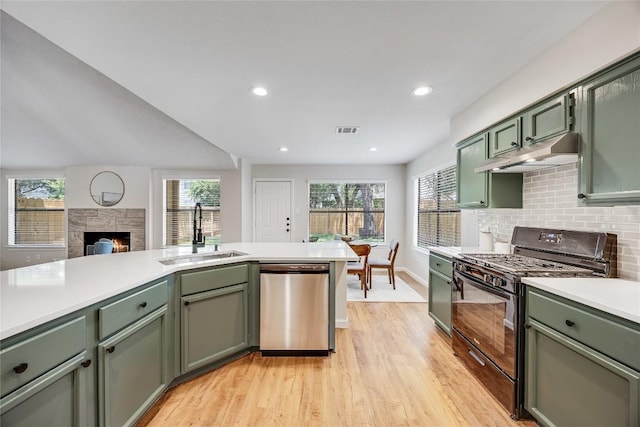 12910 Steeple Chase Dr, Austin, TX 78729 - kitchen featuring stainless steel dishwasher, green cabinets, black range with gas cooktop, under cabinet range hood, and a sink