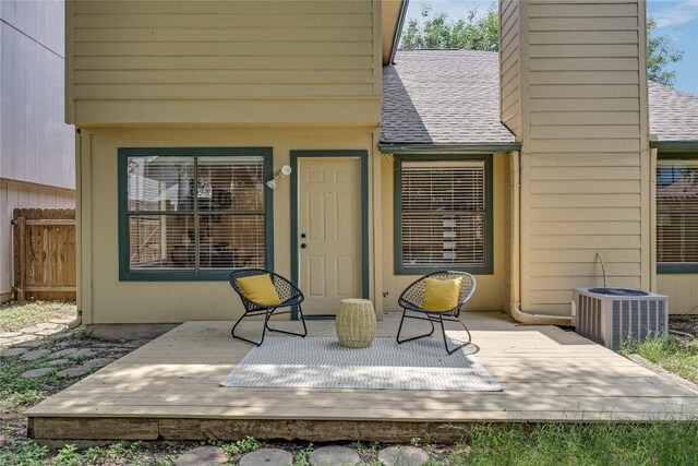12910 Steeple Chase Dr, Austin, TX 78729 - view of exterior entry featuring a shingled roof, central AC, a chimney, and a wooden deck