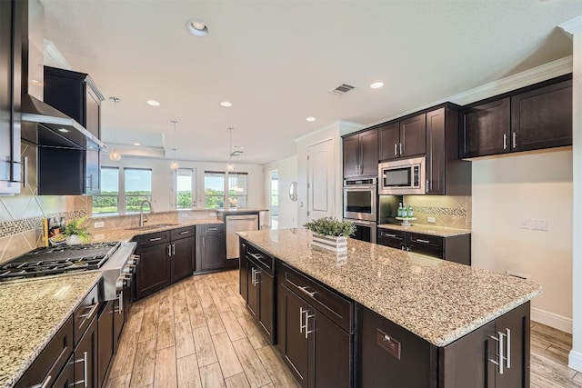 318 Fairway Ridge Rd, Georgetown, TX 78633 - kitchen with stainless steel appliances, light wood finished floors, a kitchen island, light stone countertops, and a peninsula