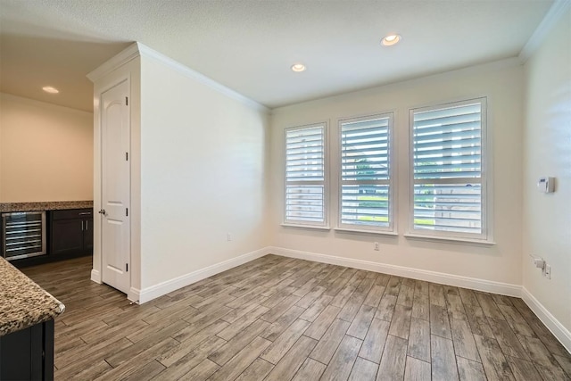 318 Fairway Ridge Rd, Georgetown, TX 78633 - unfurnished dining area featuring beverage cooler, wood finished floors, ornamental molding, baseboards, and a bar
