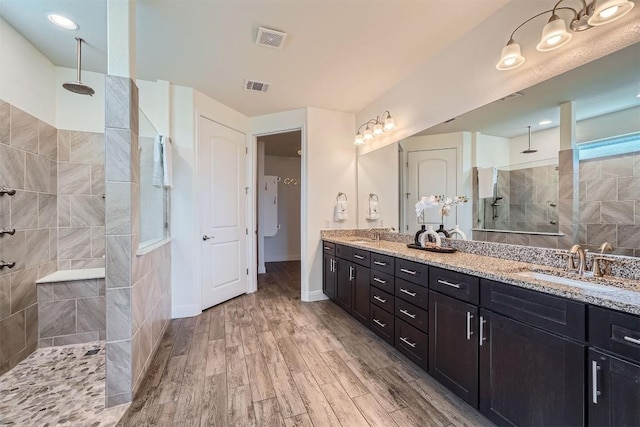 318 Fairway Ridge Rd, Georgetown, TX 78633 - full bathroom with double vanity, walk in shower, and wood finished floors