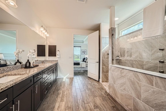 318 Fairway Ridge Rd, Georgetown, TX 78633 - ensuite bathroom featuring plenty of natural light, double vanity, wood finished floors, and a walk in shower
