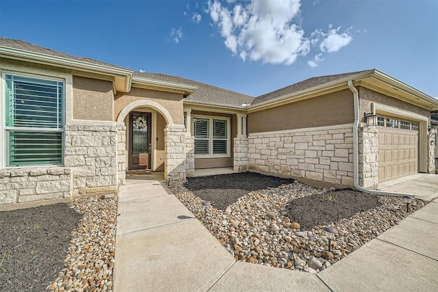 318 Fairway Ridge Rd, Georgetown, TX 78633 - view of exterior entry featuring stone siding, a garage, stucco siding, and driveway