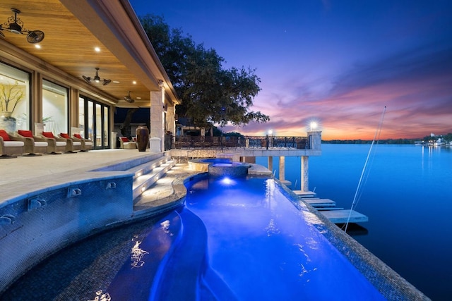 101 Matern Ct, Horseshoe Bay, TX 78657 - pool at dusk featuring a water view, a patio, a pool with connected hot tub, and ceiling fan