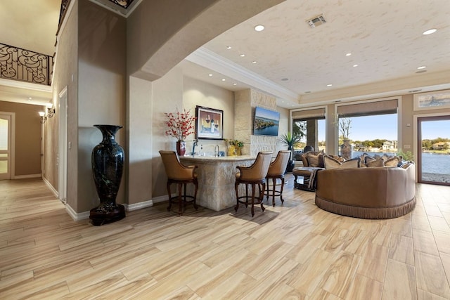 101 Matern Ct, Horseshoe Bay, TX 78657 - living area featuring crown molding, wood finished floors, wet bar, recessed lighting, and baseboards