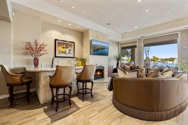 101 Matern Ct, Horseshoe Bay, TX 78657 - living room featuring crown molding, wood finished floors, recessed lighting, a fireplace, and bar with sink