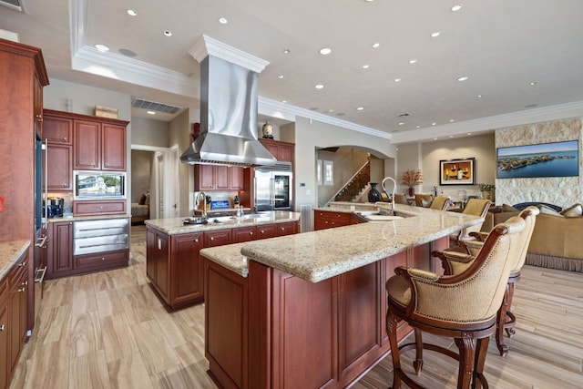 101 Matern Ct, Horseshoe Bay, TX 78657 - kitchen with a large island with sink, a sink, built in appliances, dark brown cabinets, and island exhaust hood
