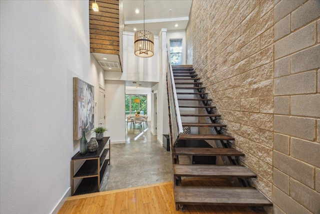 133 Frederick St Unit A, Austin, TX 78704 - stairway featuring plenty of natural light, a chandelier, a high ceiling, and wood finished floors