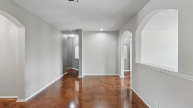 878 Avery Pkwy, New Braunfels, TX 78130 - hall featuring concrete flooring, arched walkways, baseboards, and recessed lighting
