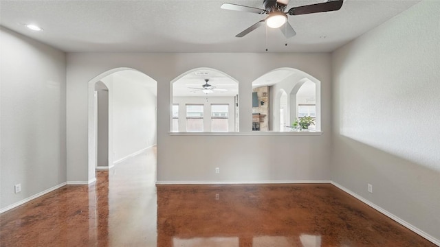 878 Avery Pkwy, New Braunfels, TX 78130 - spare room featuring ceiling fan, concrete floors, arched walkways, baseboards, and recessed lighting