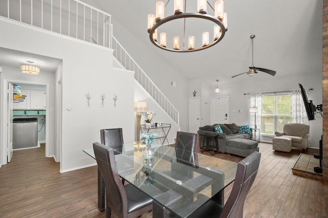 4019 Iriona Bnd, Austin, TX 78749 - dining room featuring a high ceiling, stairs, wood finished floors, ceiling fan, and a chandelier