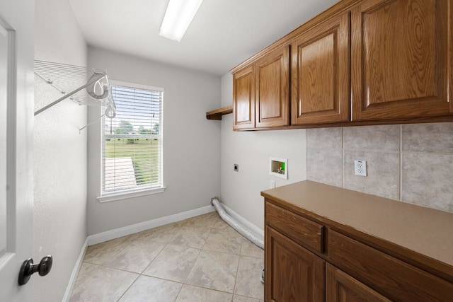 110 Starlight Trl, Georgetown, TX 78633 - laundry area featuring washer hookup, electric dryer hookup, cabinet space, light tile patterned floors, and baseboards