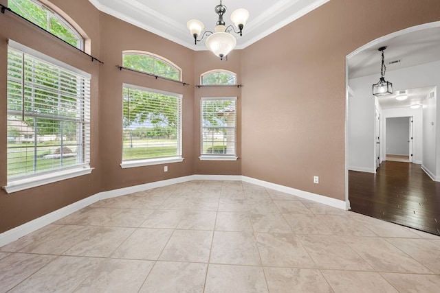 110 Starlight Trl, Georgetown, TX 78633 - tiled empty room featuring crown molding, a chandelier, arched walkways, and baseboards
