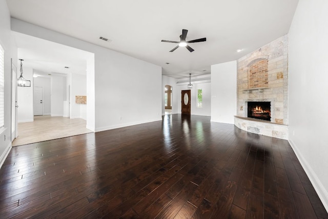 110 Starlight Trl, Georgetown, TX 78633 - unfurnished living room with ceiling fan, hardwood / wood-style flooring, a stone fireplace, and baseboards