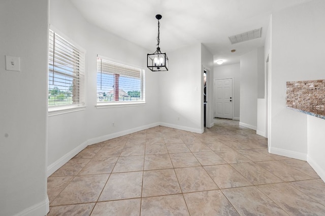 110 Starlight Trl, Georgetown, TX 78633 - unfurnished dining area with a chandelier, light tile patterned floors, and baseboards