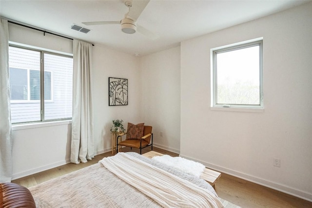 700 Denson Dr Unit 1101, Austin, TX 78752 - bedroom featuring multiple windows, wood finished floors, and ceiling fan