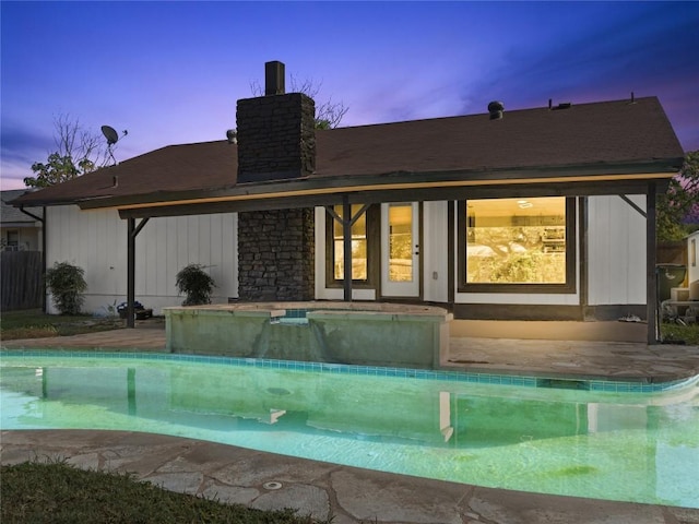 3912 Hillside Dr, Round Rock, TX 78681 - back of property featuring a chimney, an outdoor pool, and a hot tub