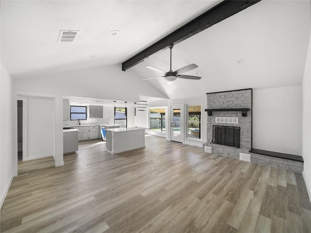 3912 Hillside Dr, Round Rock, TX 78681 - living room featuring a ceiling fan, light wood finished floors, and a stone fireplace