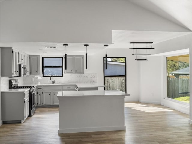 3912 Hillside Dr, Round Rock, TX 78681 - kitchen featuring stainless steel appliances, backsplash, gray cabinets, light countertops, and vaulted ceiling