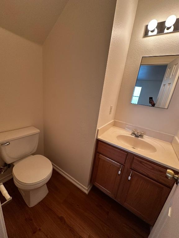 8429 Steamline Cir, Austin, TX 78745 - bathroom featuring wood finished floors, toilet, vanity, and baseboards