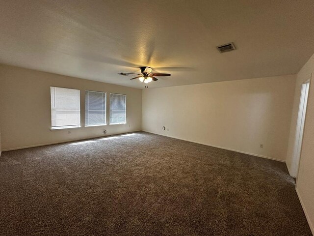 8429 Steamline Cir, Austin, TX 78745 - unfurnished room featuring a ceiling fan, dark colored carpet, and baseboards