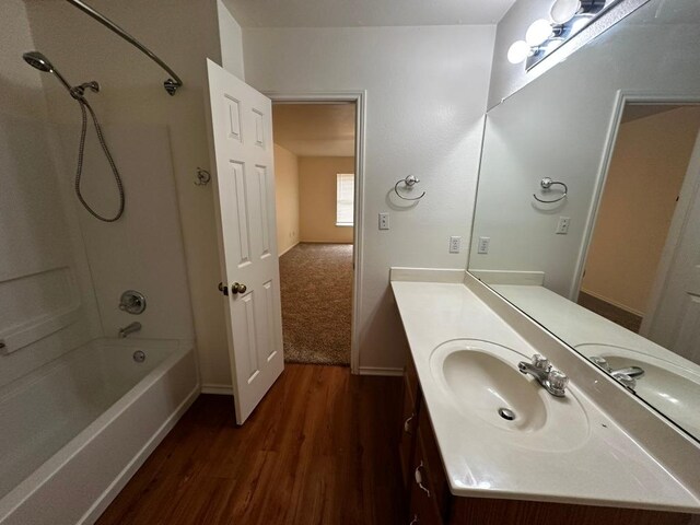8429 Steamline Cir, Austin, TX 78745 - full bathroom featuring wood finished floors, tub / shower combination, vanity, and baseboards
